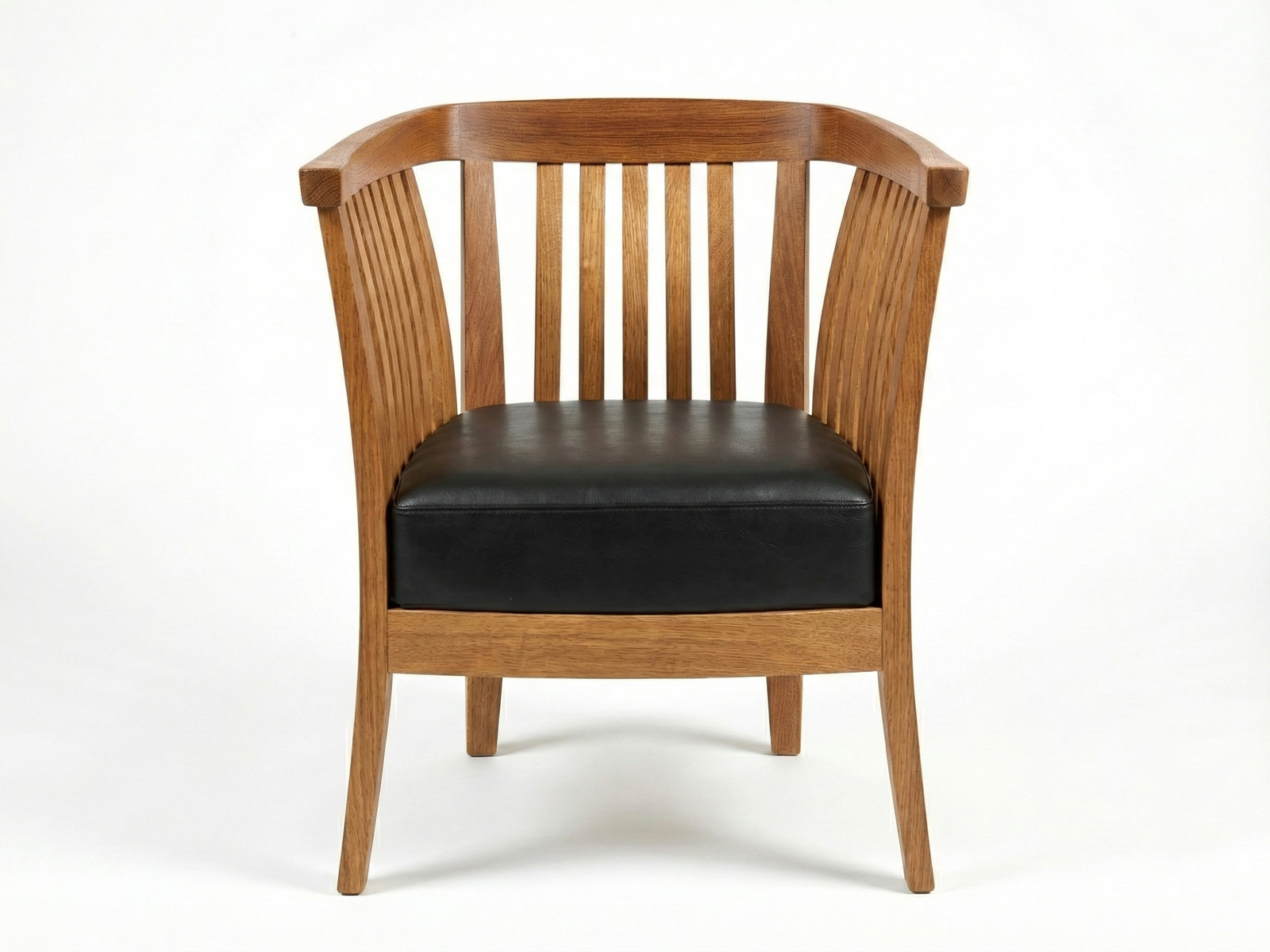 Front view of an Alvin Tub Chair, an easy chair with a wooden frame and black upholstered seat cushion. The chair is made of light to medium-brown wood, featuring a curved, slatted backrest and slatted side panels, giving it a classic, open design. It stands on four tapered wooden legs against a plain white background