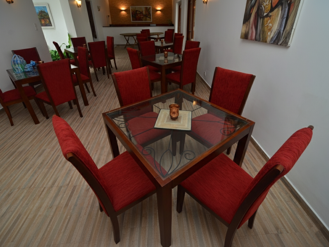 Lucas four seater dining table with a clear glass top and solid square leg frame made out of solid Mahogany timber with 4 chairs in a modern restaurant / hotel