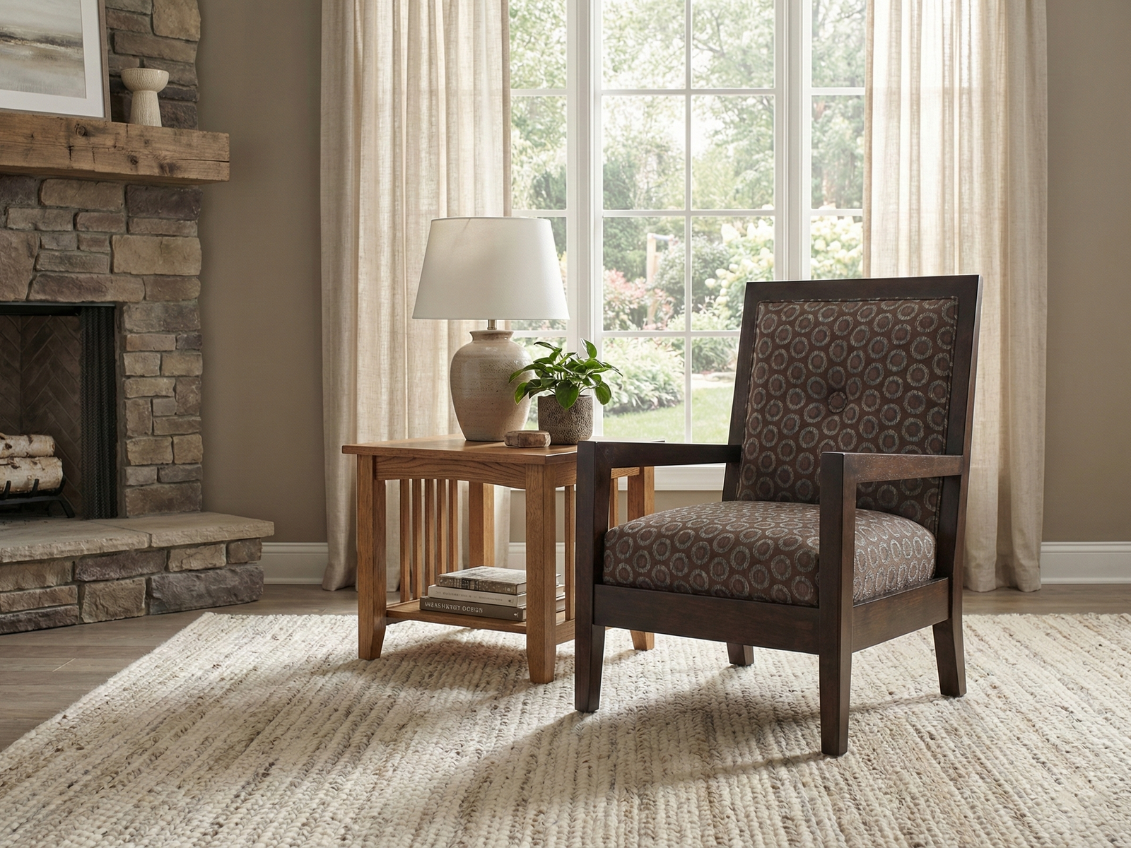 The Reese Easy Chair, an armchair with a dark wooden frame and cushions upholstered in a brown and gray circular geometric pattern, is set on a light, textured area rug. The chair is positioned next to a medium-toned wooden side table with slatted sides, which holds a ceramic lamp and a small potted plant. The setting is a cozy room with a large window overlooking a garden and a rustic stone fireplace with a wooden mantel on the left