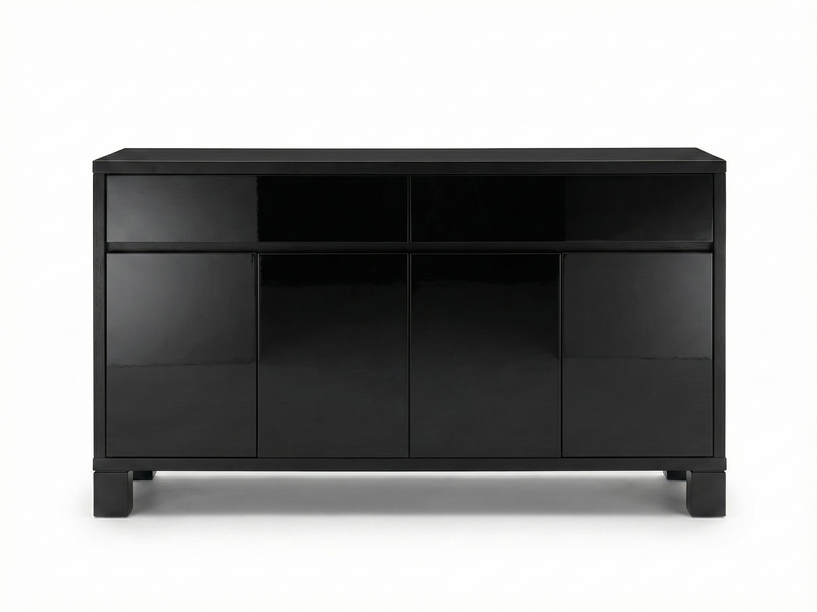 Front view of a sleek, minimalist black Ezra sideboard with a high-gloss lacquer finish. The design features a symmetrical arrangement of four handleless doors on the bottom and a recessed top section divided into two open, dark storage areas, all set against a pure white background